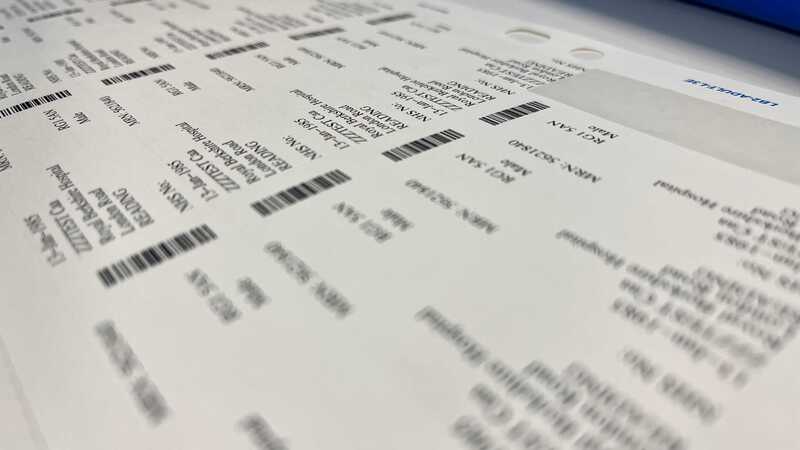 Photograph of a sheet of patient wrist tags with barcodes