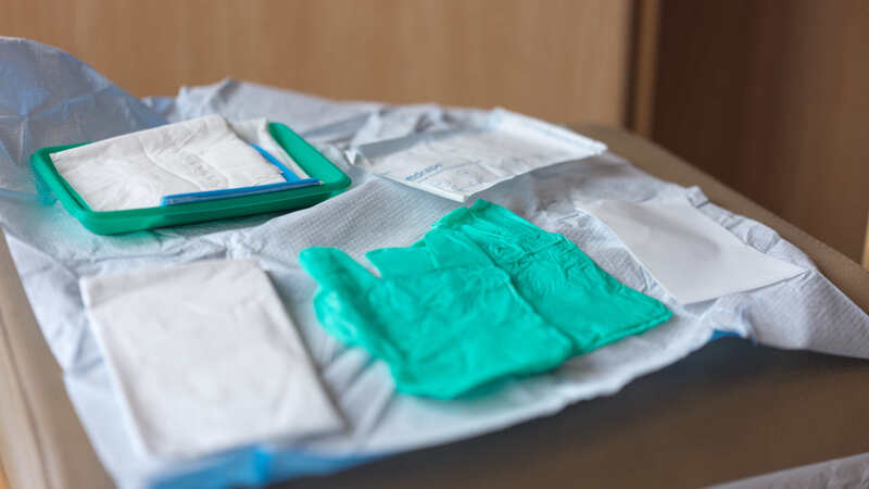 Photograph of sterlie wound dressings laid out on a white sheet with some green gloves in the forground